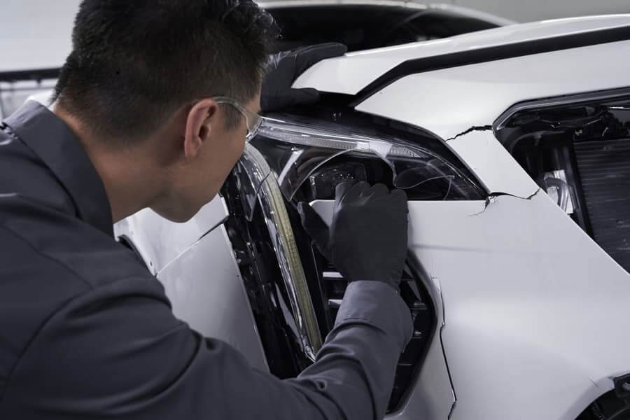 Man Fixing Cracked Bumper
