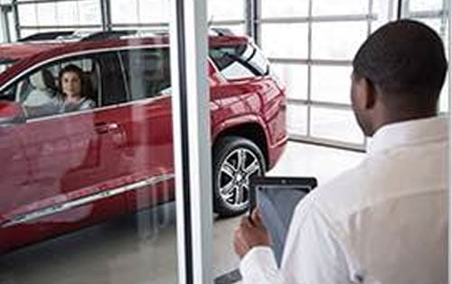 Man Viewing Car Through Glass Wall