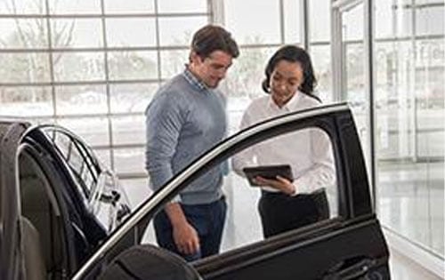 Men Looking at iPad By Car